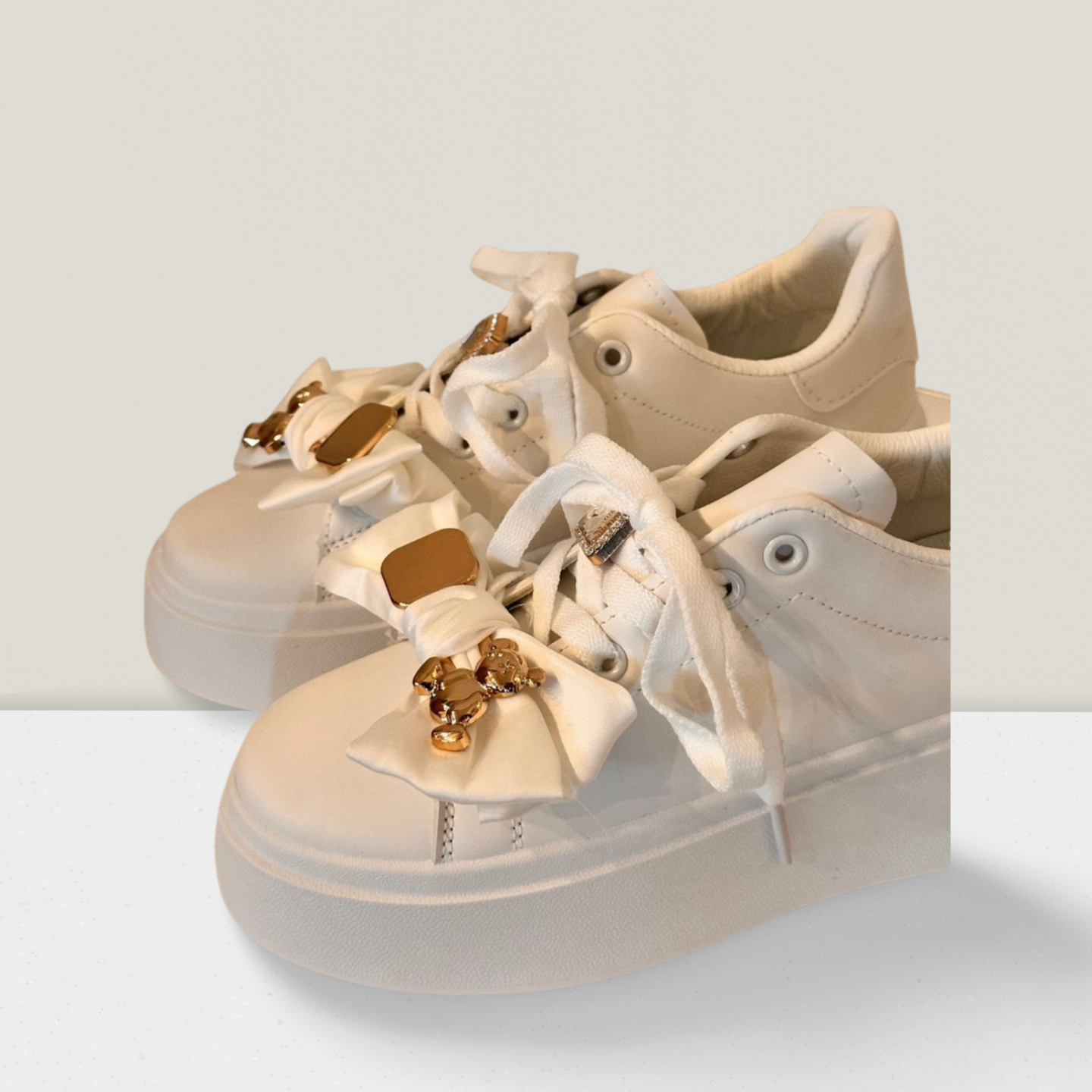 Sneakers mit Schleife und goldenen Details